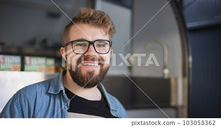 Portrait of young creative entrepreneur smiling in modern workplace copy space - Bearded millennial freelancer man in office 103058362