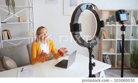 Business vlog. Online coaching. Live streaming. Positive successful woman influencer speaker shooting video lesson explaining home interior. Business vlog. Online coaching. Live streaming. Positive successful woman influencer speaker shooting video lesson explaining home interior. 103060030
