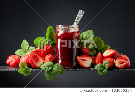 Strawberry jam and fresh berries on a black background. 103060334