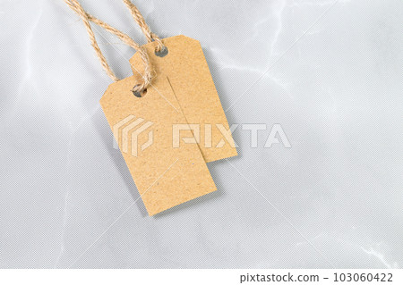 Blank tag tied with natural material string. Price tag, gift tag, sale tag, address label. Blank tag tied with natural material string. Price tag, gift tag, sale tag, address label. 103060422