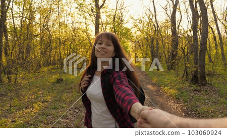 young girl holding hand man walking through woods sunset. tourist walk through forest. You come me, you come here, you call, you beckon, you approach. Happy female smile couple people love. 103060924