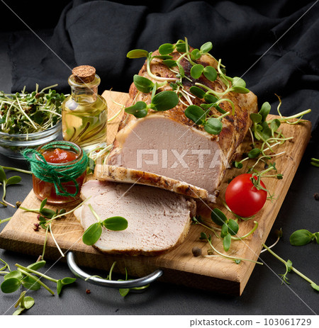Baked piece of pork balyk on the table with spices. Tenderloin cut into pieces 103061729