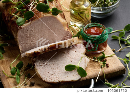 Baked piece of pork balyk on the table with spices. Tenderloin cut into pieces 103061730