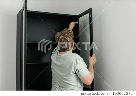 Portrait of man assembling furniture. Do it yourself furniture assembly at home 103062873