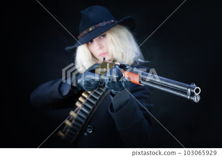 Old west blonde girl in black hat with gun 103065929