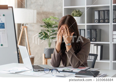 tired business woman sleepy and bored from sitting at a desk for a long time and has office syndrome 103068884