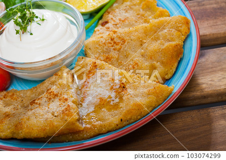 Cooked tasty potatoes pancakes with white sauce at white plate Cooked tasty potatoes pancakes with white sauce at white plate 103074299