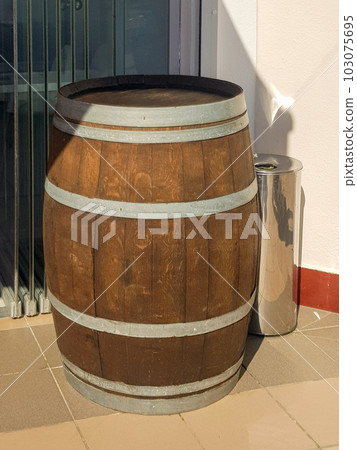 An old oak barrel stands at the entrance to a beer restaurant, shop, as an element of vintage design, vertical photo An old oak barrel stands at the entrance to a beer restaurant, shop, as an element of vintage design, vertical photo 103075695
