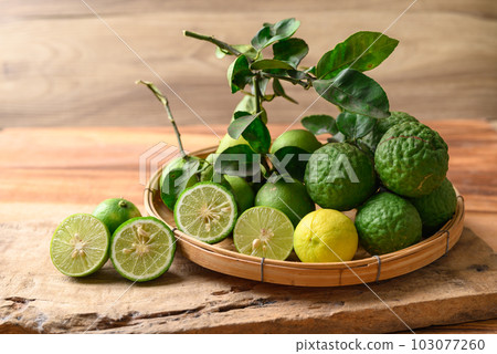 Kaffir lime and lime fruit on wooden background Kaffir lime and lime fruit on wooden background 103077260