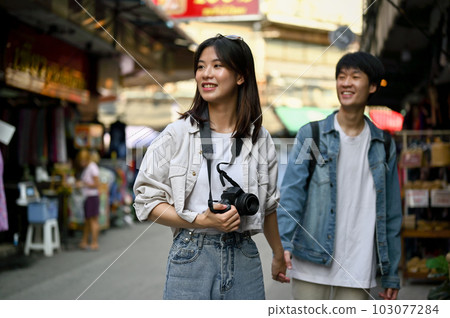 A female enjoys taking photos and sightseeing the old town market with her boyfriend 103077284