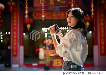 Attractive Asian woman with her camera visits a beautiful Chinese temple during her trip 103077310