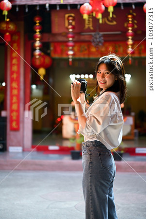A female tourist taking photos of a Chinese temple with her camera. A female tourist taking photos of a Chinese temple with her camera. 103077315