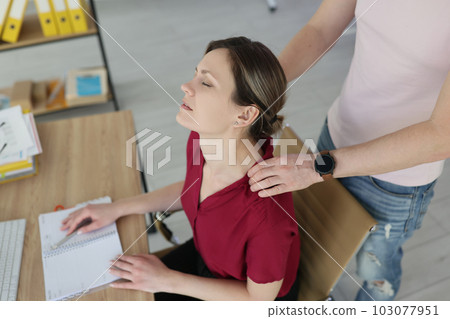 Man colleague massages shoulders of tired woman with hands Man colleague massages shoulders of tired woman with hands 103077951