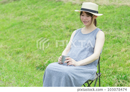 在大自然中坐在椅子上喝飲料的女人 103078474