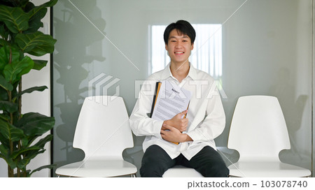 Confident Asian male candidate sits in a waiting room, waiting for his job interview. 103078740