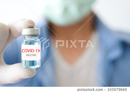 Doctor's hand holds  bottle  blue vaccine at the hospital. Health and medical concepts. 103079660
