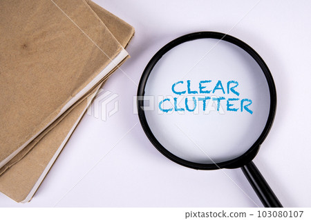Clear Clutter. Magnifying glass and book on white background Clear Clutter. Magnifying glass and book on white background 103080107