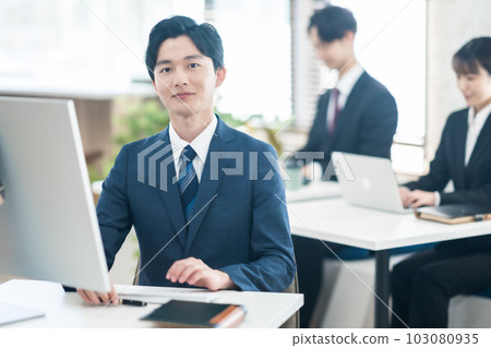 穿著西裝工作的年輕商人 穿著西裝工作的年輕商人 103080935