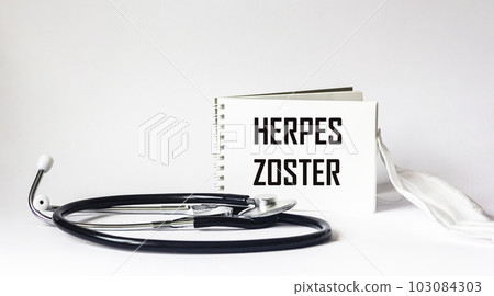 Herpes medicine concept. Notepad with the word herpes zoster and stethoscope with medical mask. Herpes medicine concept. Notepad with the word herpes zoster and stethoscope with medical mask. 103084303