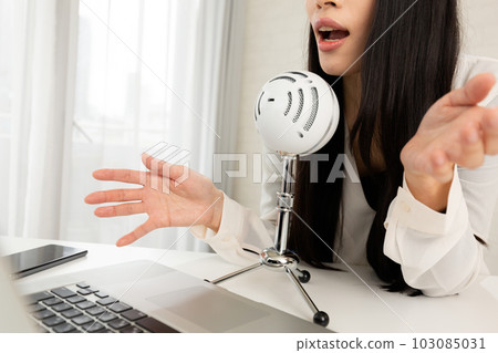 A woman speaking into a microphone. A woman speaking into a microphone. 103085031