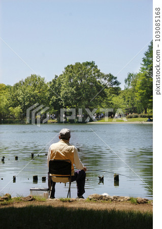 At the big pond in the park, the fisherman hangs his rod as usual. The tension of fishing while enjoying a moment of relaxation At the big pond in the park, the fisherman hangs his rod as usual. The tension of fishing while enjoying a moment of relaxation 103085168