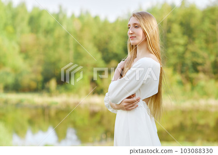 Beautiful woman in white dress on river bank 103088330