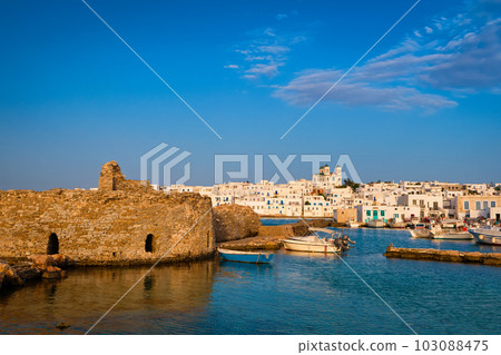 Greek whitewashed houses, old castle and church by harbour waterfront on sunny day, Naoussa, Paros island, Greece Greek whitewashed houses, old castle and church by harbour waterfront on sunny day, Naoussa, Paros island, Greece 103088475
