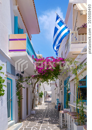Cozy streets of Greek towns, Greek national flag, bougainvillea, whitewashed cafes and bars. Cozy streets of Greek towns, Greek national flag, bougainvillea, whitewashed cafes and bars. 103088493