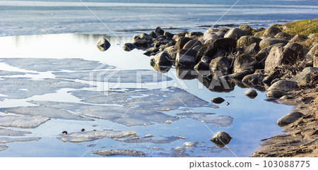 Early spring on the bank with the stones of the melting river. 103088775