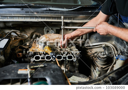 Worker, repairman opening hood of car, repairing, fixing problem. Mechanic working uniform, working in auto servicing center. Concept of repairing, fixing car. 103089000