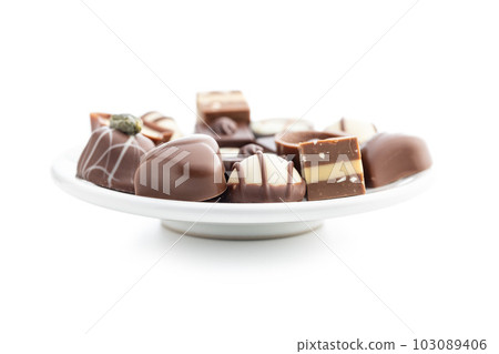Sweet chocolate pralines. Tasty chocolate truffles on plate isolated on white background. Sweet chocolate pralines. Tasty chocolate truffles on plate isolated on white background. 103089406