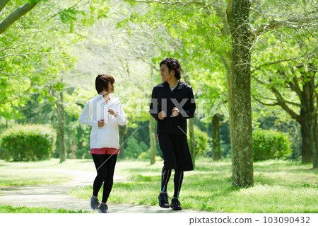 Young couple running in the park 103090432