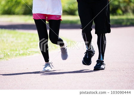 Feet of a young couple running in the park Feet of a young couple running in the park 103090444
