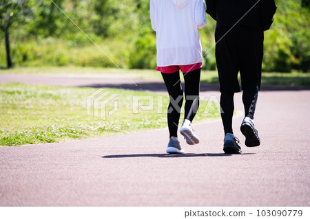 Feet of a young couple running in the park 103090779