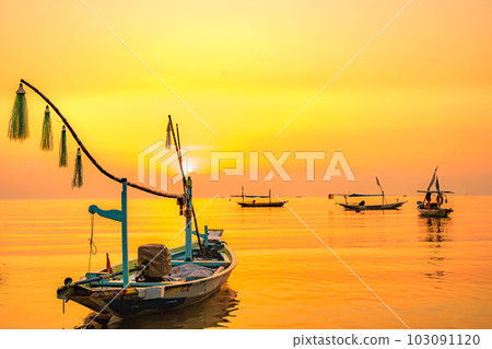 Moored boats during sunrise with yellow sky in Kenjeran, Surabaya, Indonesia. 103091120