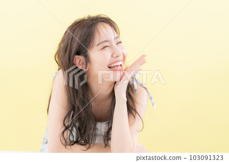 Young woman doing skin care with yellow back Young woman doing skin care with yellow back 103091323