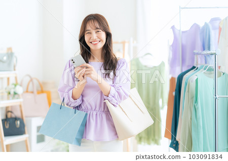 在商店購物時操作智能手機的年輕女性 103091834