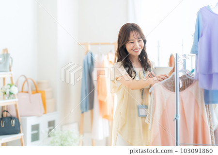 年輕女店員在服裝店操作平板電腦時工作 103091860
