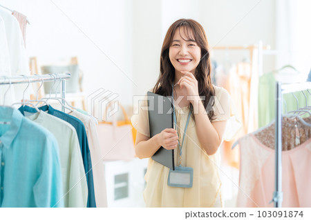 Young female clerk working in an apparel shop Young female clerk working in an apparel shop 103091874
