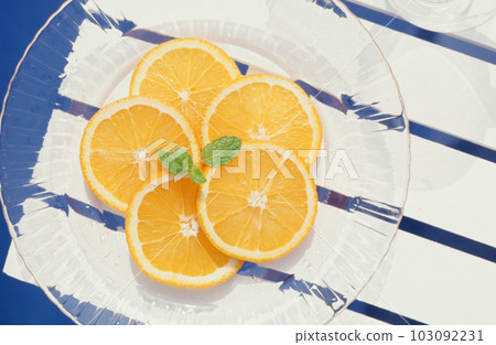 Cool glass plate and orange slice 103092231