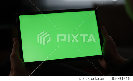 Man at home lying on a couch with tablet pc with green screen Man at home lying on a couch with tablet pc with green screen 103093746