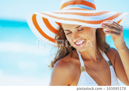 happy young woman in swimsuit and beach hat at seasi 103095178