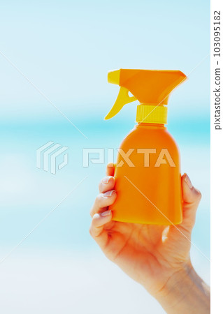 Closeup on bottle of sun screen creme in hand of woman Closeup on bottle of sun screen creme in hand of woman 103095182