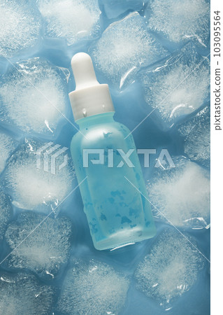 Bottle of blue serum on ice cubes and water background. 103095564