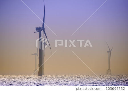 Fans of wind turbines spin over the sparkling sea. Fans of wind turbines spin over the sparkling sea. 103096332