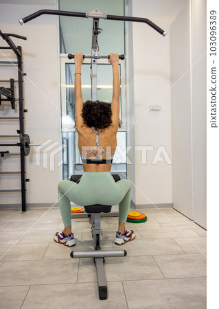 Young woman exercising in the gym and looking involved 103096389