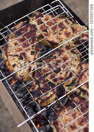 Pork meat in an iron mesh. Barbecue meat. Roast pork. Pork loin. 103097168