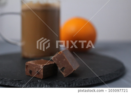 chocolate candy with coffee and orange slices on a grey tray with coffee and orange in the background. Handmade candies. Dessert and coffee chocolate candy with coffee and orange slices on a grey tray with coffee and orange in the background. Handmade candies. Dessert and coffee 103097721