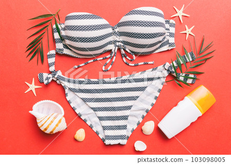 Woman swimwear and beach accessories flat lay top view on colored background Summer travel concept. bikini swimsuit, straw hat and seasheels. Copy space Top view 103098005