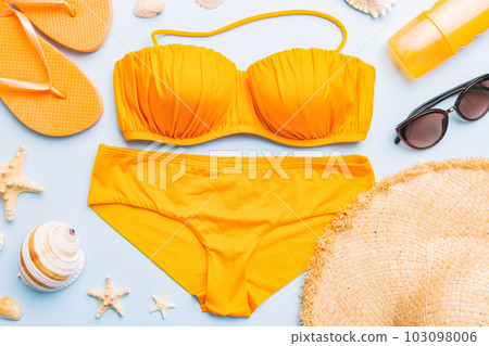 Woman swimwear and beach accessories flat lay top view on colored background Summer travel concept. bikini swimsuit, straw hat and seasheels. Copy space Top view 103098006